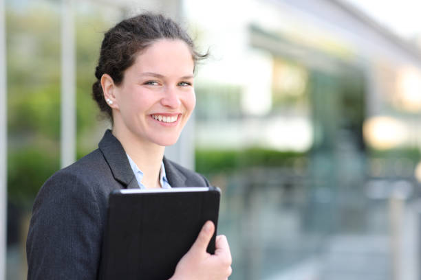 Happy executive looks at camera in the street