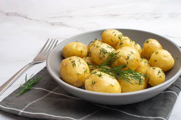 istock Young potatoes with butter and dill in a gray plate on a white background 1502221006