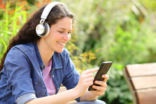 istock Happy female listening audio content in a park 1502221072