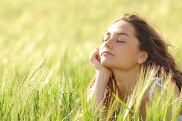 istock Woman closing eyes relaxing mind in a field 1502221097