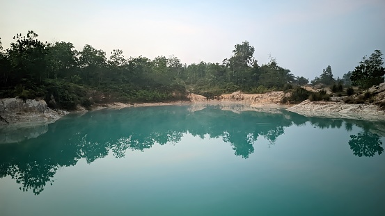 beautiful blue lake view in the morning with reflection of a row of tropical forests above the water surface, Tin Mining Area in Bangka Belitung Island
