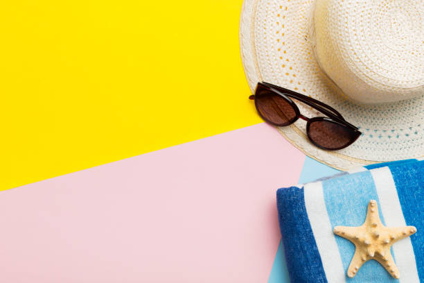 istock Beach accessories straw hat and seashell on colored table. Summer concept background 1502226064