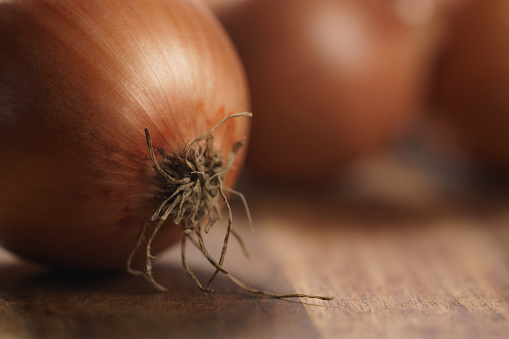 brown onions on old wood table, shallow focus