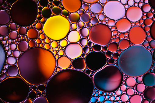 multi colored oil circles on the water, colorful background