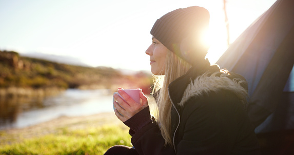 Woman, thinking and tent camp with coffee by a river in morning in summer by lake. Mockup, young female person and tea at sunrise on holiday, travel and vacation with freedom from camping outdoor