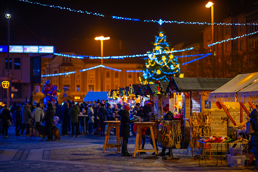 Decorated and illuminated Christmas market with crowded street outdoors at night