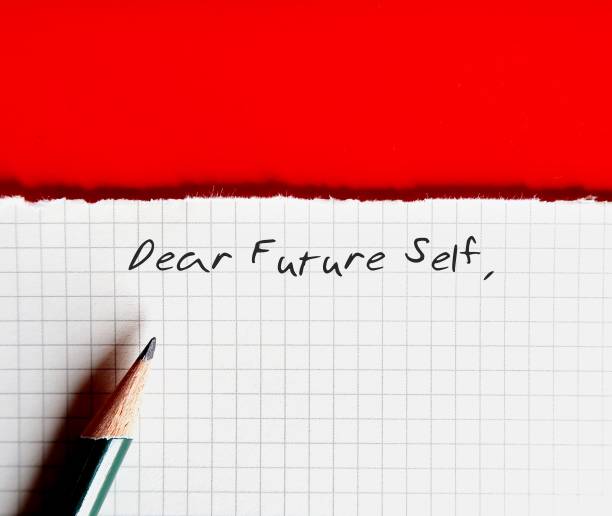 istock On orange background, torn paper with handwritten text DEAR FUTURE SELF, a letter to convey message to future you. specific goals to achieve, follow up on bucket list items or declare important affirmation 1502265480