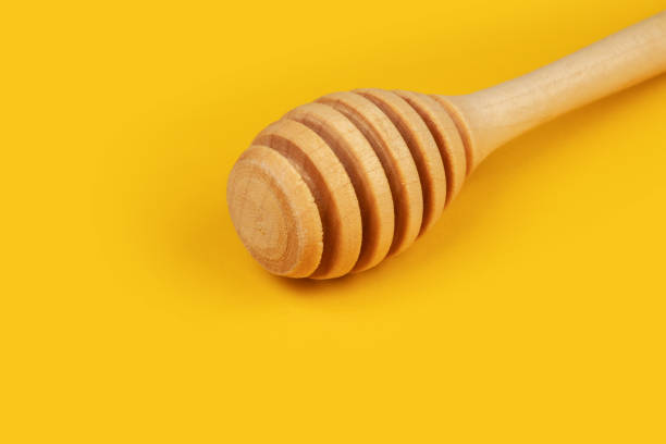 istock clean wooden honey spoon on yellow background 1502273543