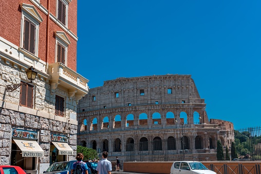Rome, Italy – August 01, 2016: A partial view of the Rome Colosseum from one of the streets at a high level showing the architecture and business