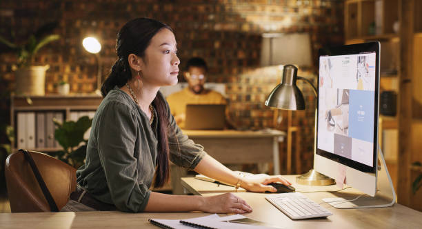istock Woman in office, overtime and research on computer at design agency, web development and information online. Late work, Asian project manager or designer in digital marketing with planning and focus. 1502276958