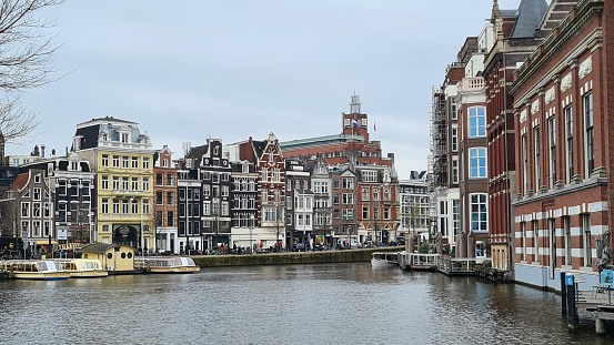 Amsterdam, Netherlands – March 21, 2023: Traditional houses and a canal in the downtown of Amsterdam.
