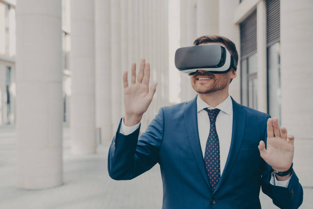 istock Professional architect in AR headset outdoors, gesturing and smiling, excited businessman using 3D goggles for work, moving virtual objects in air. 1502283964