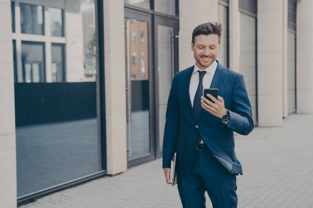 istock Confident consultant with smartphone, smiling outdoors after work, reading positive project news from colleague. 1502283969