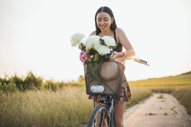 Smiling woman with bicycle enjoying nature