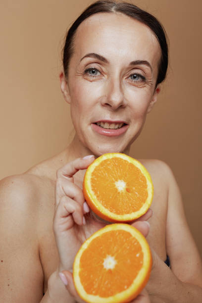 istock modern female with orange against beige background 1502292018