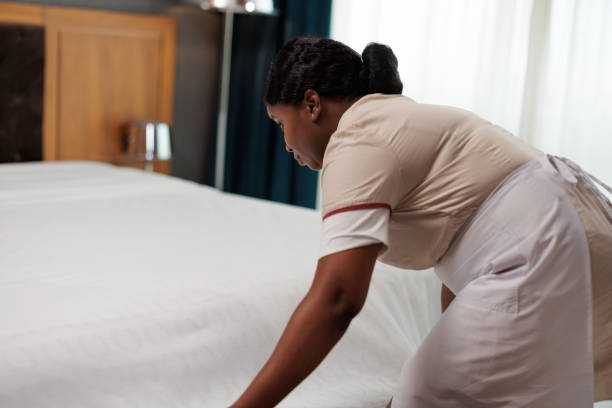 istock African-American hotel maid fixing bed sheets 1502303442