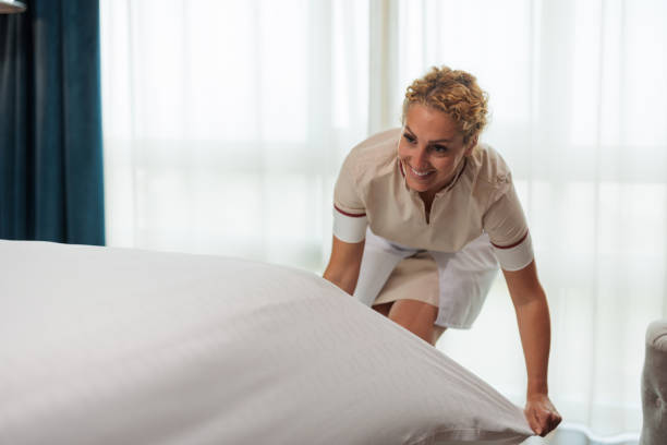 istock Happy Caucasian hotel maid tightening sheets 1502304089