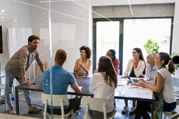 istock Smiling diverse colleagues gather in boardroom brainstorm discuss financial statistics together 1502311476