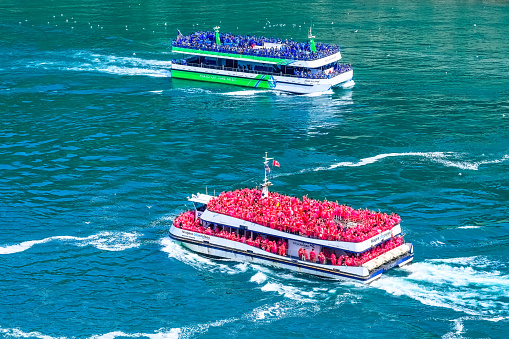 Niagara Falls, Ontario, Canada - June 17, 2023: Tour boat or small boats carrying passengers in the Niagara River. The ride is a tourist attraction
