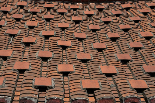 Aerial view of pitched tiled roof (rooves) on old English houses. Line of plain clay ridge tiles and roof valley, UK