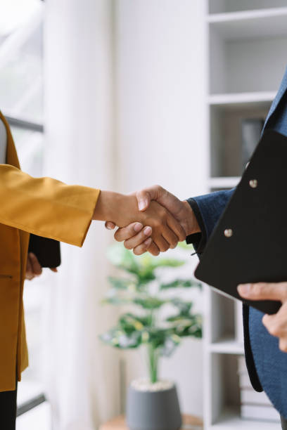 Business men and women shake hands confidently at an office meeting. stock photo