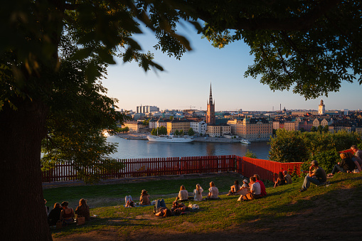 Panoramic view of the Stockholm City Skyline from Ivar Los Park on Mariaberget, Södermalm, with people taking in the view in the sunset.