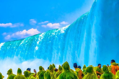 Niagara Falls, Ontario, Canada - June 17, 2023: Group of tourists at the base of the Horseshoe waterfall.