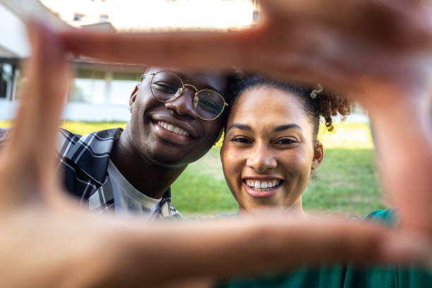istock Happy, smiling young African American couple making frame with fingers looking at camera. Loving relationship 1502320404