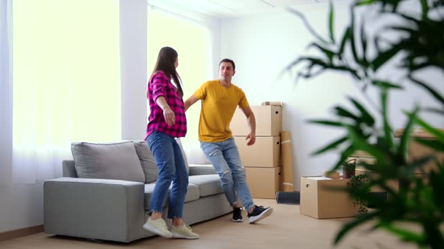 Young couple carrying sofa in their new home