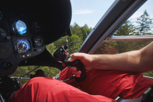 Pilot Helicopter Emergency Medical Service during flight above forest. Close-up of flight control inside cockpit.