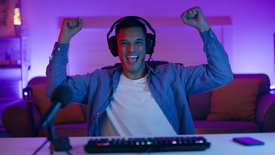 Gaming success, man or portrait of excited gamer winning playing arcade competition with bonus achievement. Person, yes or happy streamer in celebration or streaming fun computer video games at home