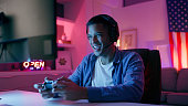 Happy man, video game and headphones with live streaming and esports, computer and gamer playing in gaming room. Technology, competition and winning with male person, cyber world and controller