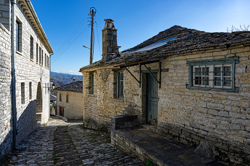 Street with historic buildings and a stream on the outskirts of Falaise