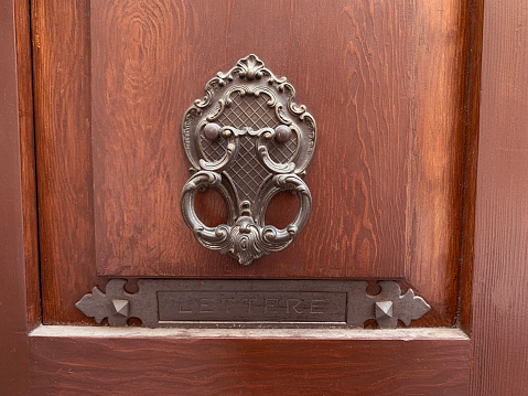Wooden door with metal door knocker, closeup of photo