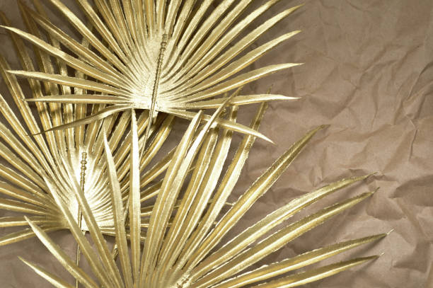 istock abstract gold background with palm leaves on a craft paper 1502380294