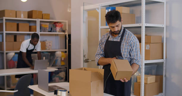 istock Young manager in post room packing order for distribution 1502381430