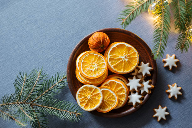 istock Dried oranges, ginger cookies on plate, fir branches on blue tablecloth background. Christmas holiday festive decoration,  greeting card, banner template. Top view, copy space 1502386138