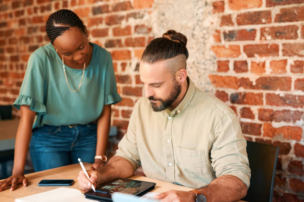 istock Teamwork, tablet or web designers planning in meeting in discussion, collaboration or mentorship in startup. Research, digital business or developers talking or planning with notes or diary schedule 1502387767