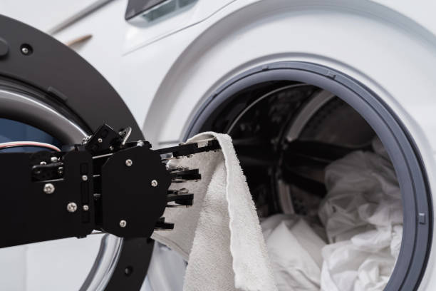 istock Real robot's hand and washing machine. Concept of Artificial intelligence development and robotic process automation. 1502390859