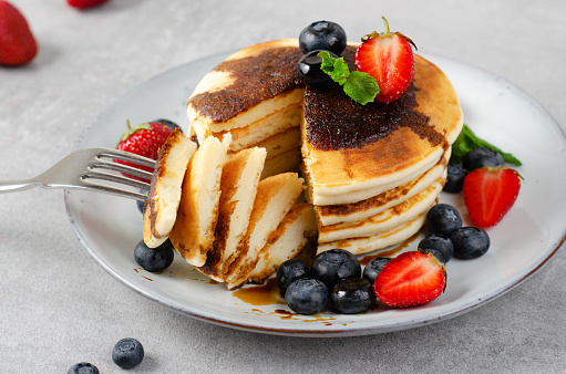 Pancakes with Fresh Berries and Maple Syrup, Tasty Breakfast on Bright Background