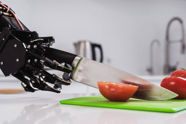 istock Real robot's hand cutting fresh tomatoes with sharp knife. Concept of robotic process automation 1502393623