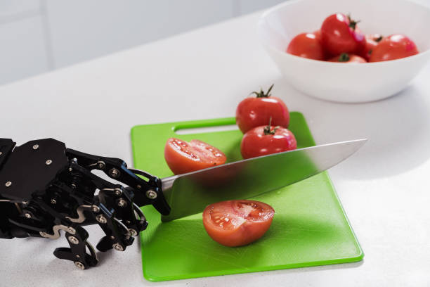 istock Real robot's hand cutting fresh tomatoes with sharp knife. Concept of robotic process automation 1502394161