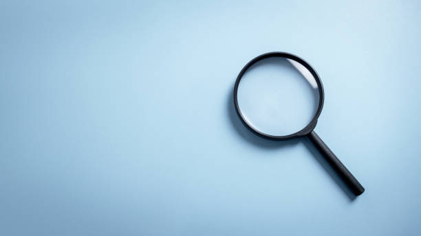 Top view empty lens black magnifying glass on white blue pastel background. Flat lay object and inspection investigate science equipment tool concept. Police forensic science theme. Copy space. stock photo