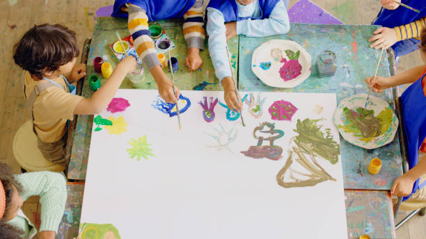 istock Creative, class and kids painting on a canvas in school for art learning, lesson or knowledge. Brushes, paint and children students or friends creating artwork on a board with mockup for education. 1502416696
