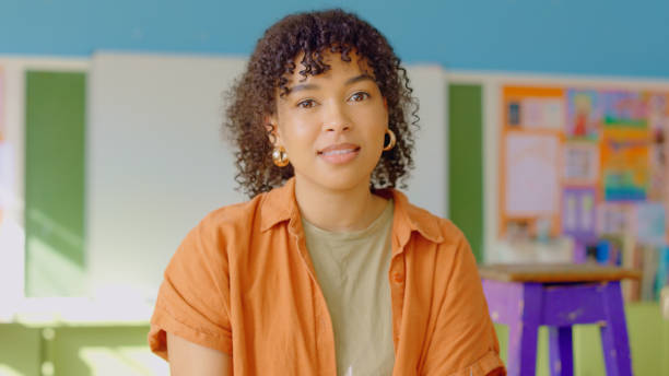 istock Happy, portrait and female art teacher sitting in her classroom, studio or workshop before a lesson. Smile, artistic and professional young woman artist, painter or educator in her creative class. 1502416700
