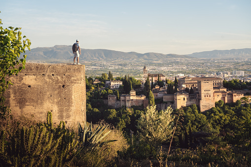 Tourist looking at Alhambra view from San Miguel Alto Viewpoint - Granada, Andalusia, Spain
