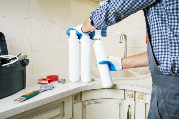 reparador instalando cartuchos de filtro de agua en una cocina. sustitución del filtro de agua, purificación de agua. - distilled water fotografías e imágenes de stock