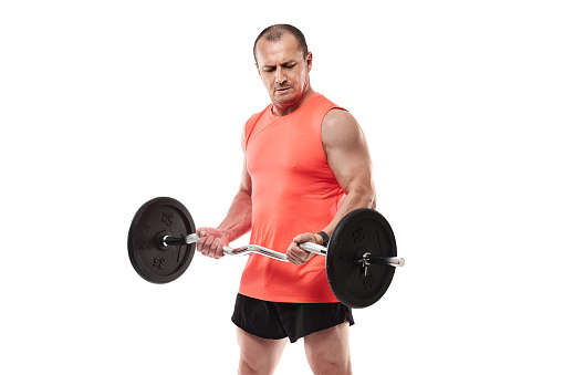 Mature athletic man in pink tee doing fitness workout with barbell and weights, isolated on white background