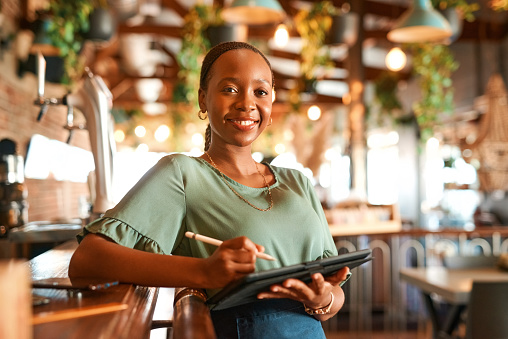 Restaurant, black woman or portrait of business owner with tablet, confidence or pride in modern startup. Happy, entrepreneur or African woman manager with leadership writing notes in a fancy cafe
