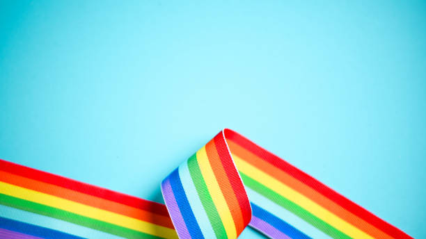 cintura con fiocco a nastro arcobaleno su sfondo blu con spazio di copia. concetto di mese dell'orgoglio lgbtq+ e pride day. - symbols of peace flag gay pride flag banner foto e immagini stock